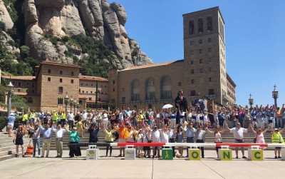 Afiliados y trabajadores catalanes posan en Montserrat ante un gran bastón rojo-blanco, símbolo de las personas sordociegas