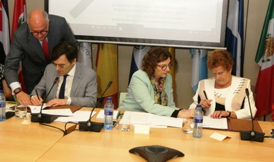 Alberto Durán y Cristina Sanz fIrman el acuerdo FOAL-ICEVI, en presencia de la secretaria general adjunta de la SEGIB, Mariangela Rebuá (en el centro) 