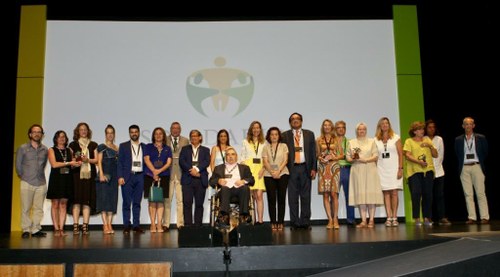 Foto de familia de los galardonados sobre el escenario junto con los responsables institucionales
