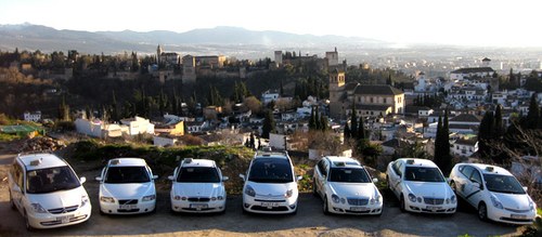 Flota de taxis con la Alhambra de Granada al fondo