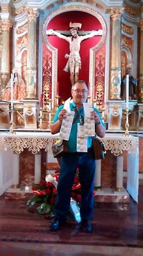 Juan Segundo Nieto posa delante de la imagen del Cristo de la Salud de la Puebla de Almoradiel (Toledo), con los cupones de la ONCE