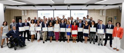 Foto de familia de todos los galardonados, luciendo sus diplomas, junto a los representantes de ILUNION