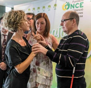 Francina Armengol (en el centro) conversa con el sordociego Francisco González gracias a la labor de su mediadora, Kusiy Volt