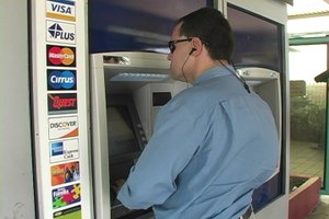 Una persona ciega utiliza un cajero automático adaptado con terminal de voz