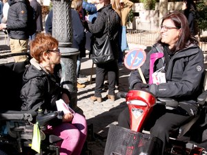 Dos mujeres en silla de ruedas conversan en el transcurso de la concentración en Madrid