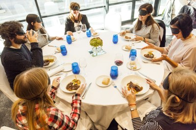 Una de las mesas con los participantes comiendo a ciegas