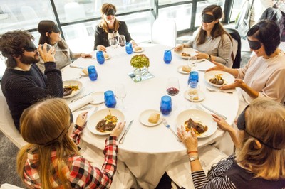 Una de las mesas con los participantes comiendo a ciegas