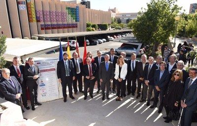 Autoridades y personal universitario, en la inauguración de la macrotabla periódica, que se observa al fondo sobre la fachada del edificio