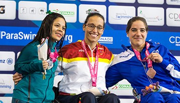 Perales, en el centro, feliz con su oro en 100 libres, junto a la segunda y tercera clasificadas