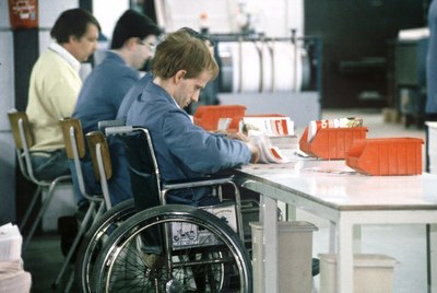 Un hombre con discapacidad trabaja, desde su silla de ruedas, en un servicio de paquetería