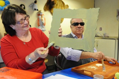 Dos afiliados mayores (una mujer y un hombre) trabajan en un taller de manualidades