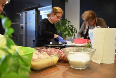 Dos de las participantes en el taller de cocina, en plena faena entre fogones
