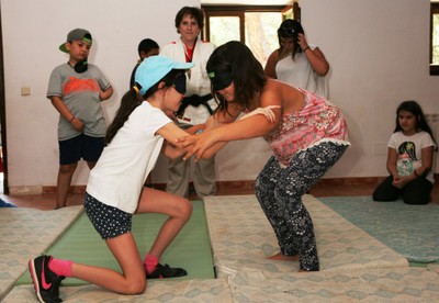 Dos niñas practican judo bajo la atenta mirada de una de las instructoras del campus