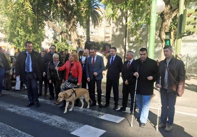 El alcalde y el delegado territorial de la ONCE (en el centro) cruzan uno de los nuevos semáforos adaptados, junto a varias personas ciegas