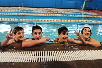 Un grupo de jóvenes afiliados se divierte en la piscina en una sesión de cursillo de Natación