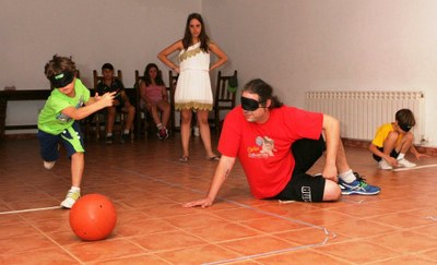 Un niño, provisto de un antifaz opaco, practica el goalball durante uno de los campus deportivos del último verano