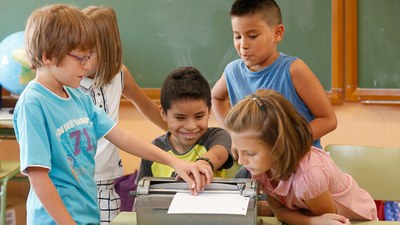 Un niño ciego, en el aula, enseña a sus compañeros videntes, el funcionamiento de la máquina Perkins de escribir braille