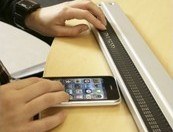 Una persona maneja una línea braille de ordenador junto a su smartphone