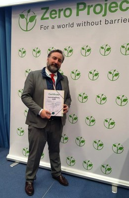 José Luis Borau posa con el diploma que acredita la distinción del trabajo de Fundación ONCE sobre Turismo Accesible