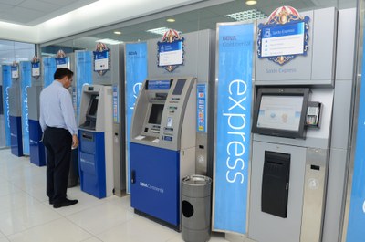 Una persona saca dinero en un espacio de cajeros de BBVA