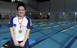 Ariadna, sonriente, al borde de la piscina, con una de sus medallas colgada al cuello