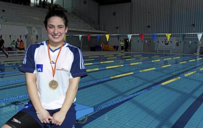 Ariadna, sonriente, al borde de la piscina, con una de sus medallas colgada al cuello