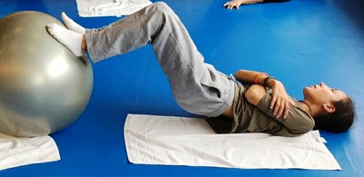 Una de las jóvenes con discapacidad visual realizando ejercicios de Pilates sobre el suelo