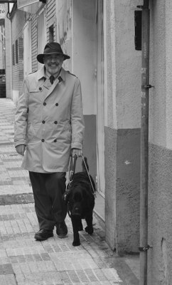 Luis Clemente camina junto a su perro guía Keisa (imagen en blanco y negro) 