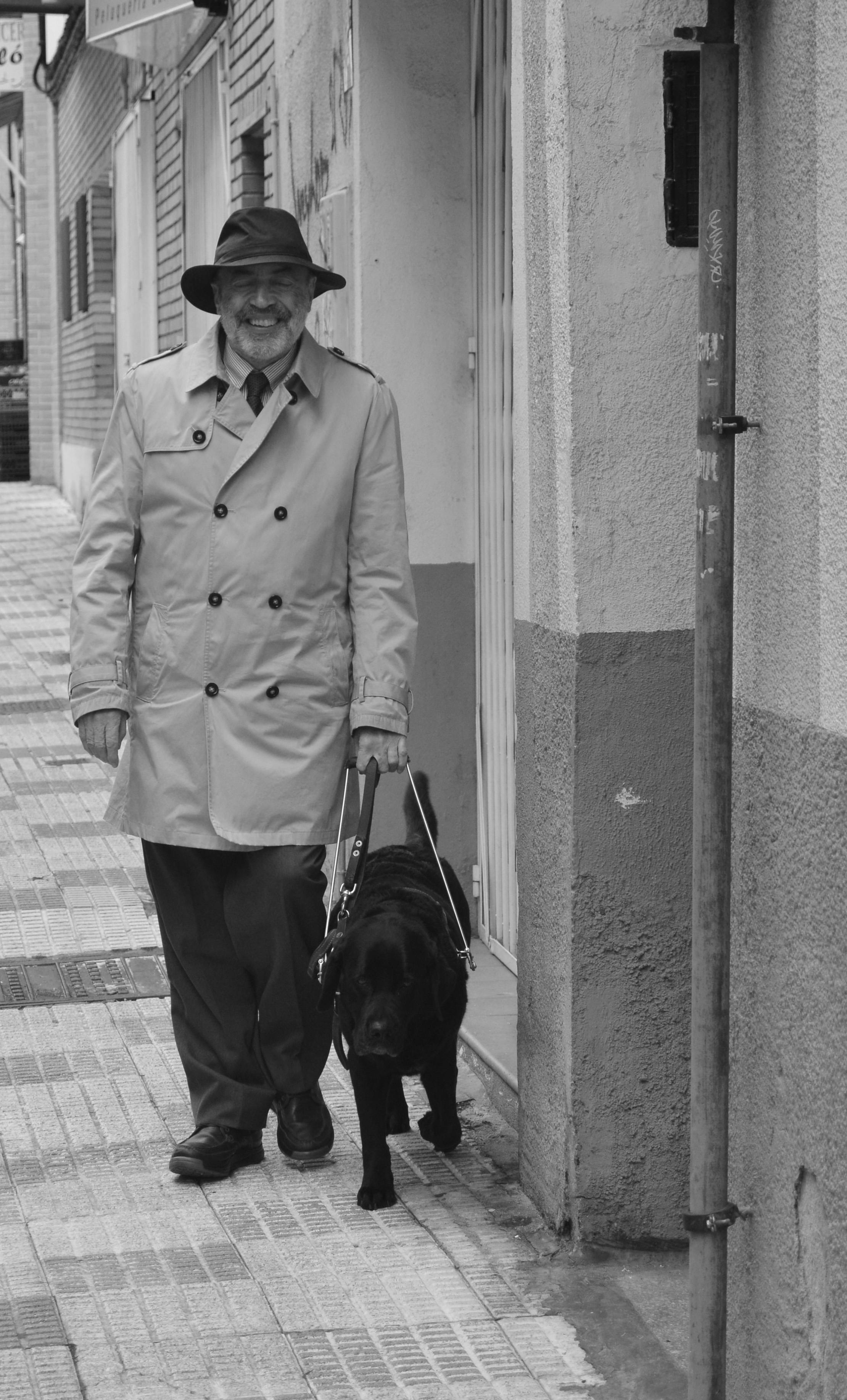 Luis Clemente camina junto a su perro guía Keisa (imagen en blanco y negro) 
