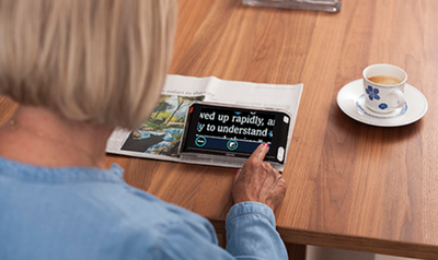 Una mujer lee un texto ampliado con la función ZoomText en su tablet