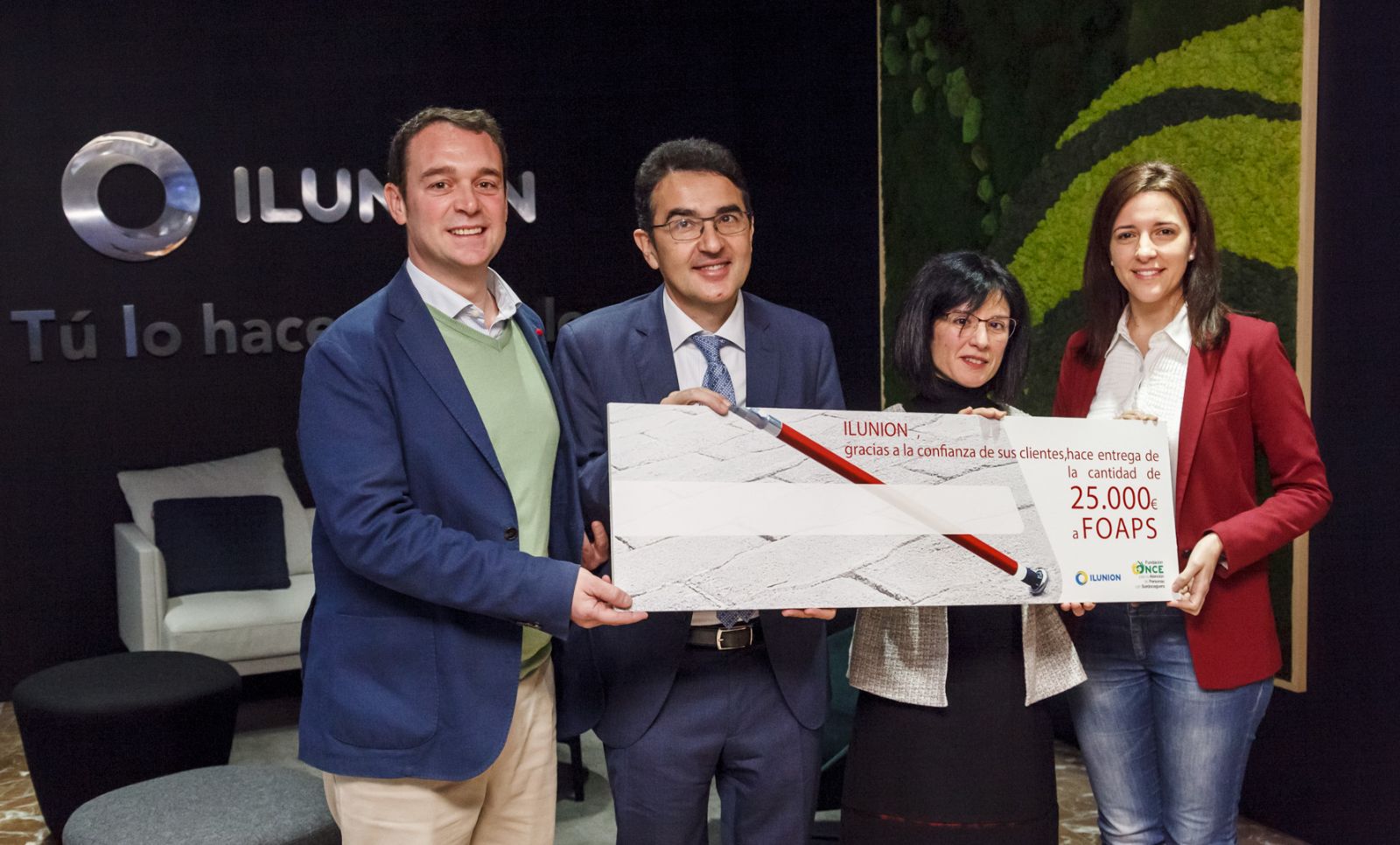 Andrés Ramos (segundo por la izquierda) recoge el cheque del que le hacen entregan trabajadores de ILUNION