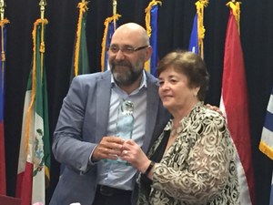 Eugenio Romero recoge el premio, en nombre de Pilar Gómez, de manos de la vicepresidenta de Deafblind International, Bernadette Kappen 