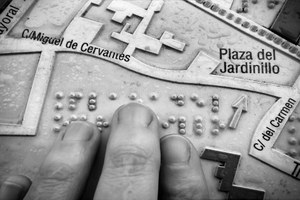 Premio Castilla La Mancha: una mano reconoce al tacto un mapa/itinerario urbano, en relieve y braille, con indicación de calles y monumentos