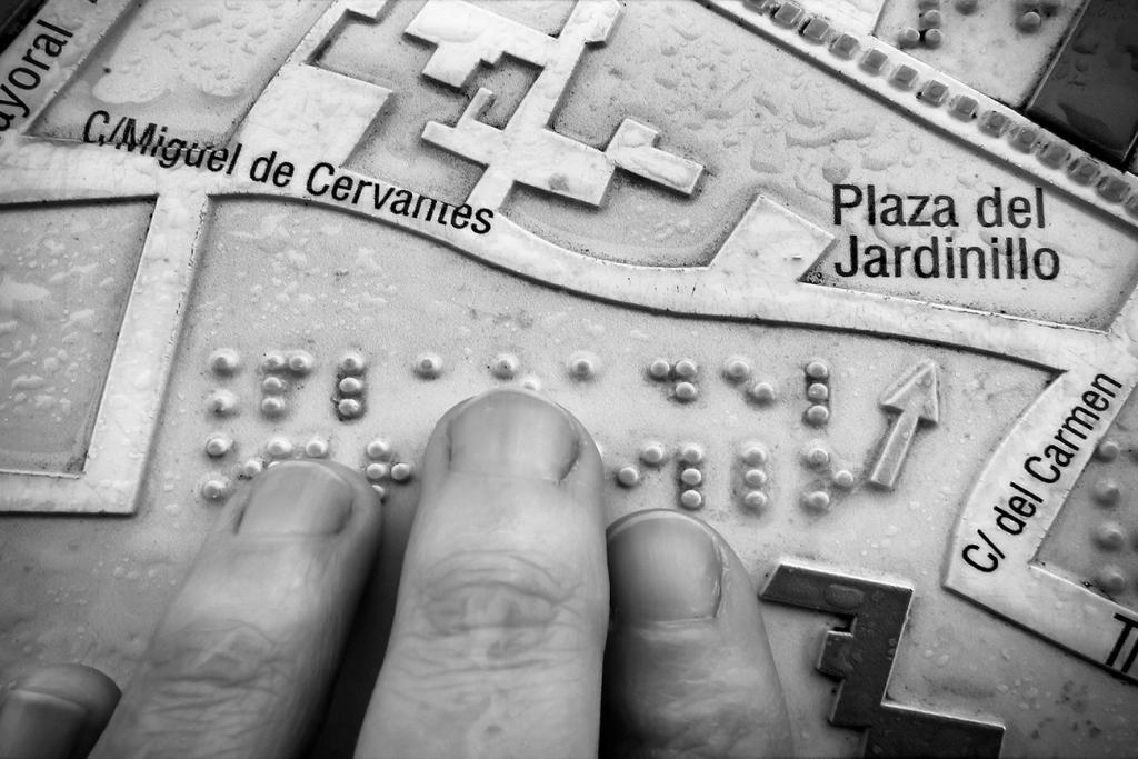 Premio Castilla La Mancha: una mano reconoce al tacto un mapa/itinerario urbano, en relieve y braille, con indicación de calles y monumentos