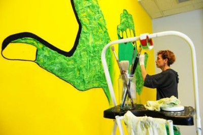 Kelly Arrontes en plena ejecución del mural