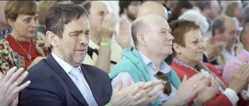 Ex alumnos asistentes al acto institucional aplauden una de las intervenciones