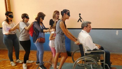 Familiares practicando a caminar a ciegas, conduciendo al tiempo a una persona en silla de ruedas