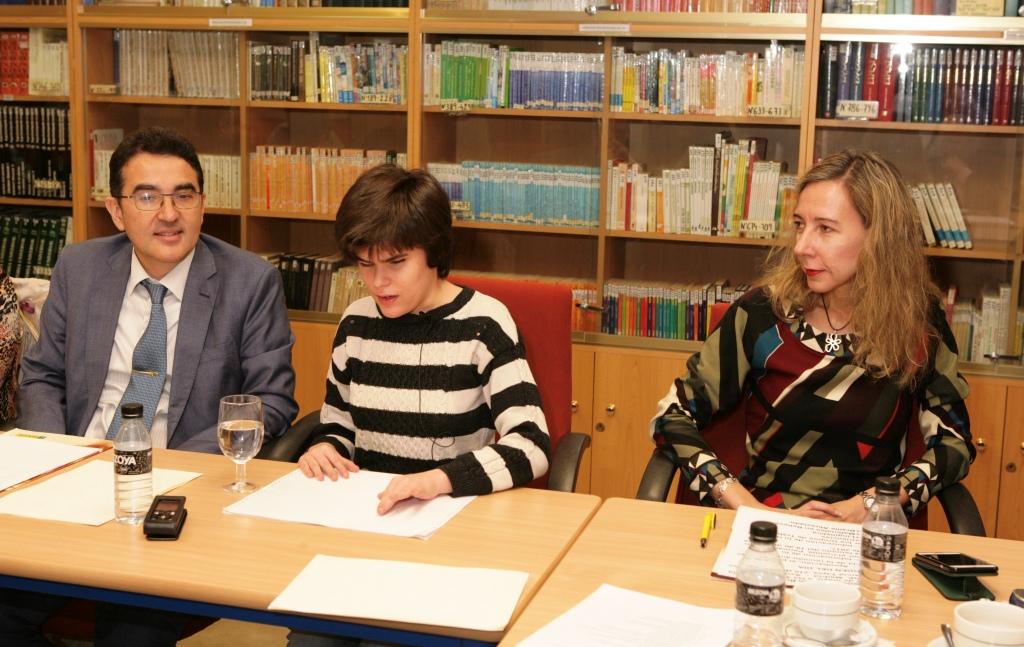 Sara lee el manifiesto sobre el braille ante el Pleno de la CBE, acompada por Andrés Ramos y la vicepresidenta de la ONCE, Patricia Sanz