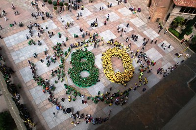 Decenas de afiliados, ataviados de verde y amarillo, forman un número 80 en la plaza central de Montserrat