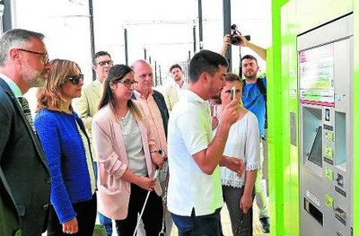 Un joven ciego prueba con su móvil el funcionamiento de la aplicación, en una parada del tranvía, durante la inauguración oficial