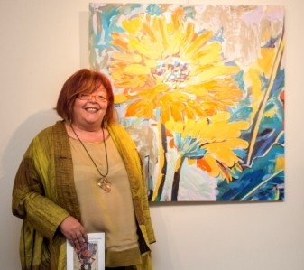 Luz Galván con su obra Gerberas naranjas y amarillas 