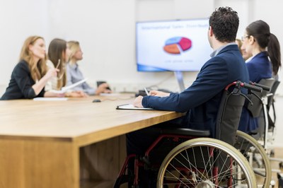 Un hombre en silla de ruedas, durante una reunión de trabajo en su empresa