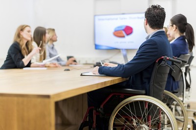 Un hombre en silla de ruedas, durante una reunión de trabajo en su empresa