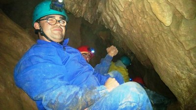 Afiliados atravesando una de las grietas de la gruta
