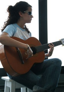 Una joven afiliada tocando la guitarra española