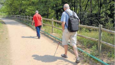 Una persona ciega, con su bastón, recorriendo la Vía Verde de Girona