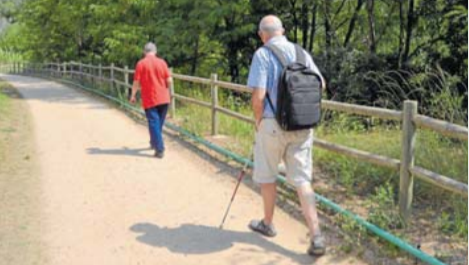 Una persona ciega, con su bastón, recorriendo la Vía Verde de Girona