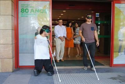 Gay (a la izquierda) e Ignacio Escartín dan un paseo por el entorno de la Delegación con los ojos tapados y valiéndose tan sólo del bastón como guía
