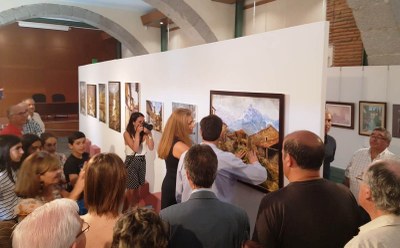 La presidenta territorial de la ONCE Arancha Casado aprecia al tacto las características de una pintura en la inauguración de la muestra en Ávila