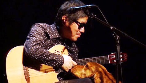 Yunpeng, junto a su perro guía, sobre el escenario durante una actuación
